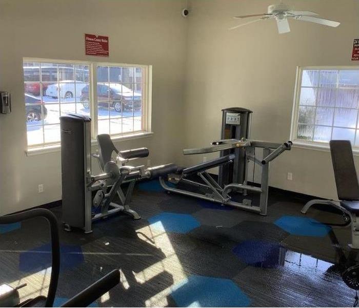 Workout equipment sits in flooded gym